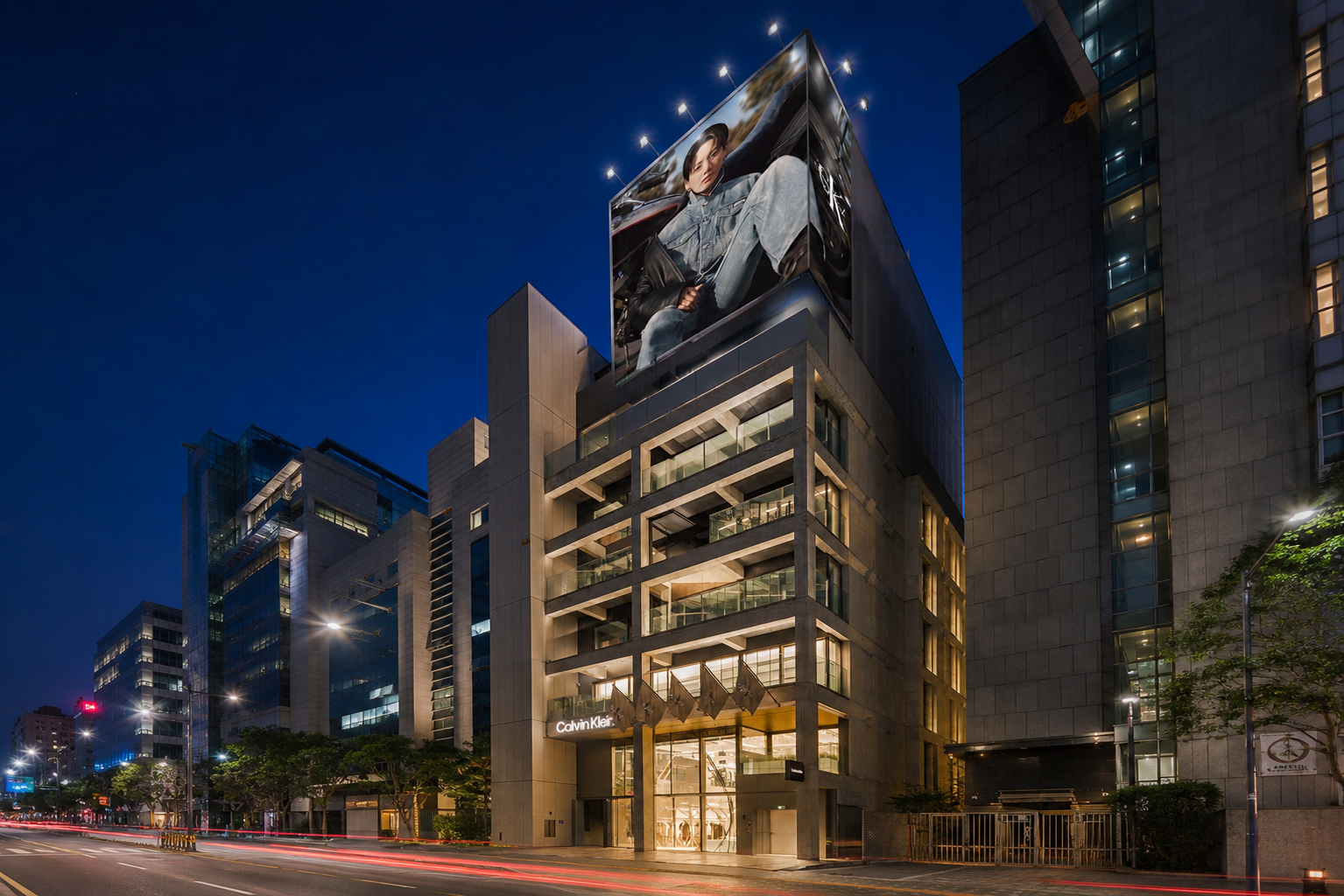 Illuminated Calvin Klein storefront and light trails at night